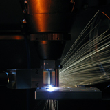 Laser drilling of tantalum using a hybrid nozzle